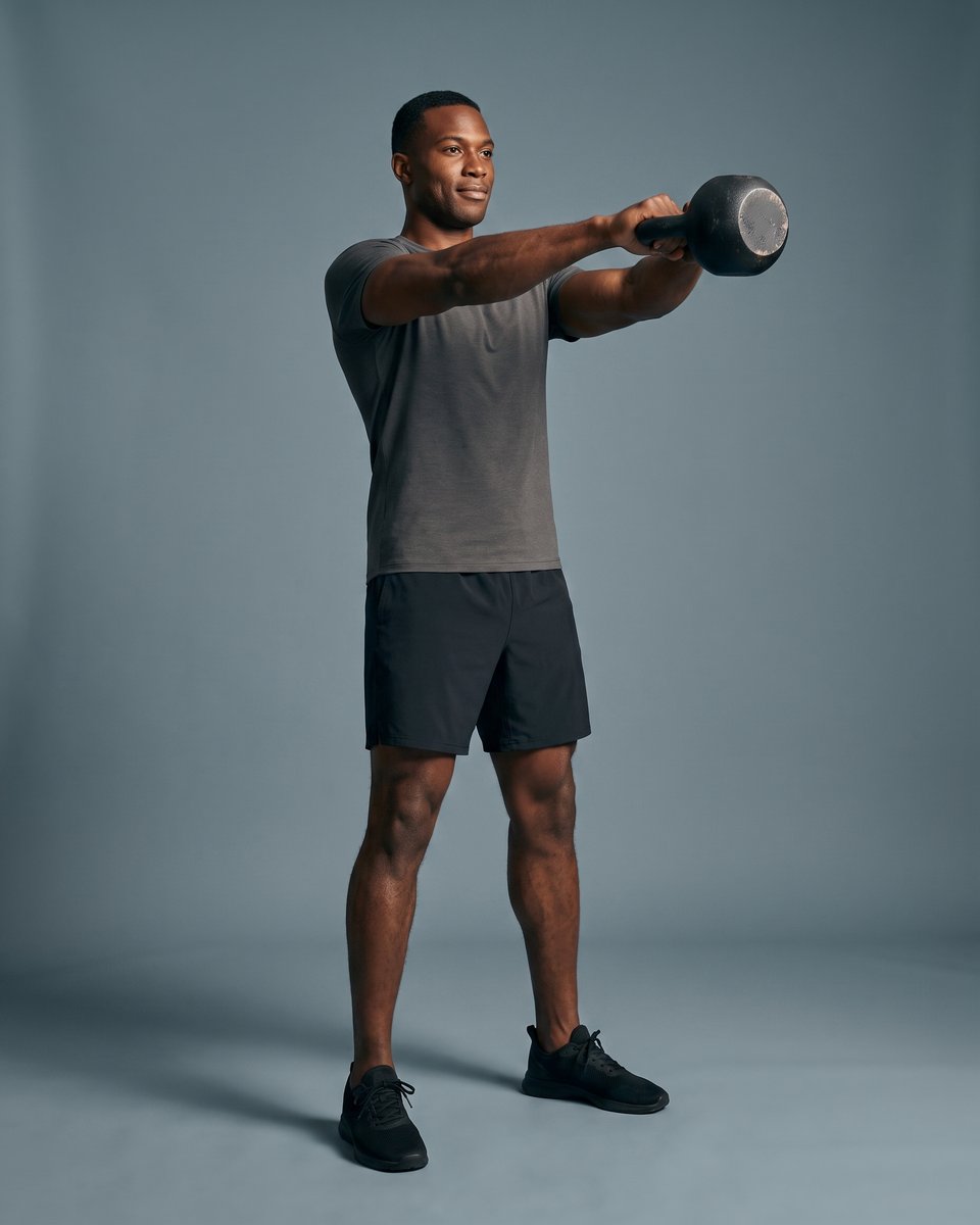 An athlete at the top of a kettlebell swing
